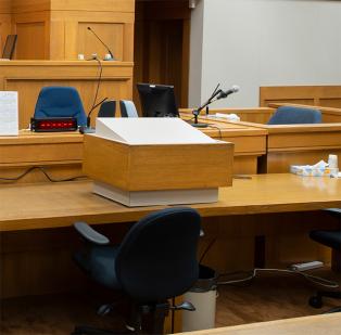 Counsel desk and podium with microphone inside courtroom.
